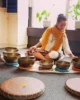 Woman meditating with Tibetan singing bowls during a sound healing session